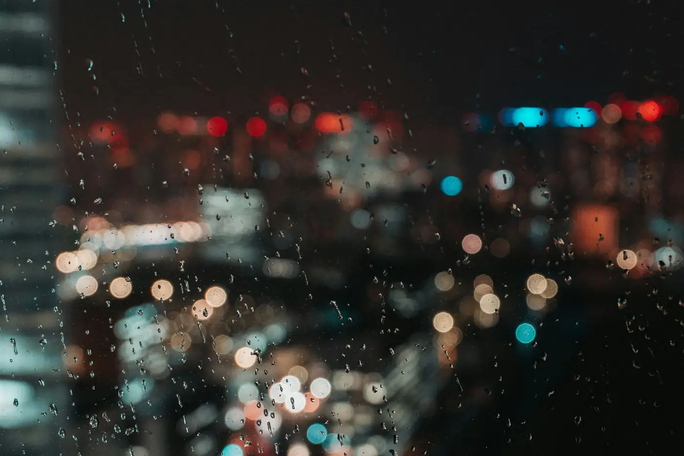 City lights at night, seen through a rain-covered window